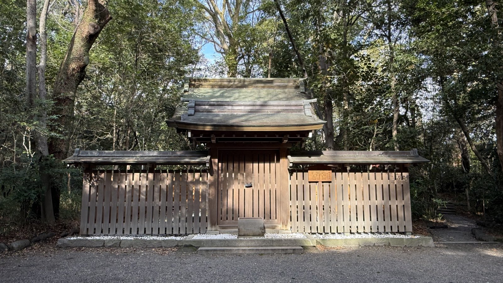 A small shrine enclosed by a wooden fence