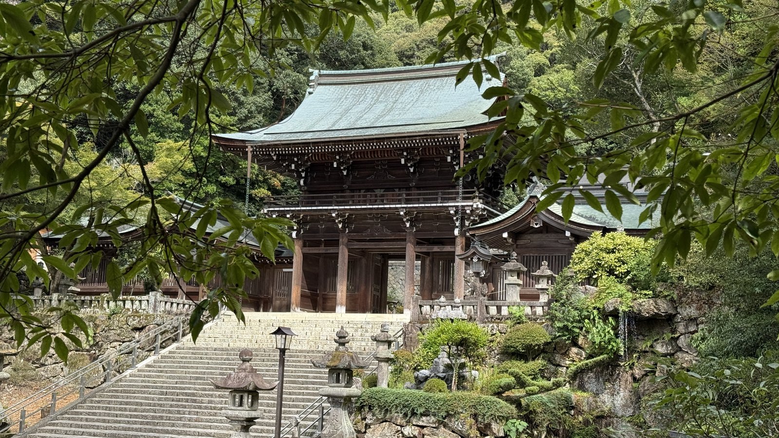 The two-storey gate, seen through the branches of the trees