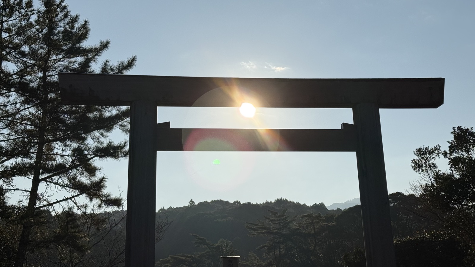 A torii silhouetted against the morning sun