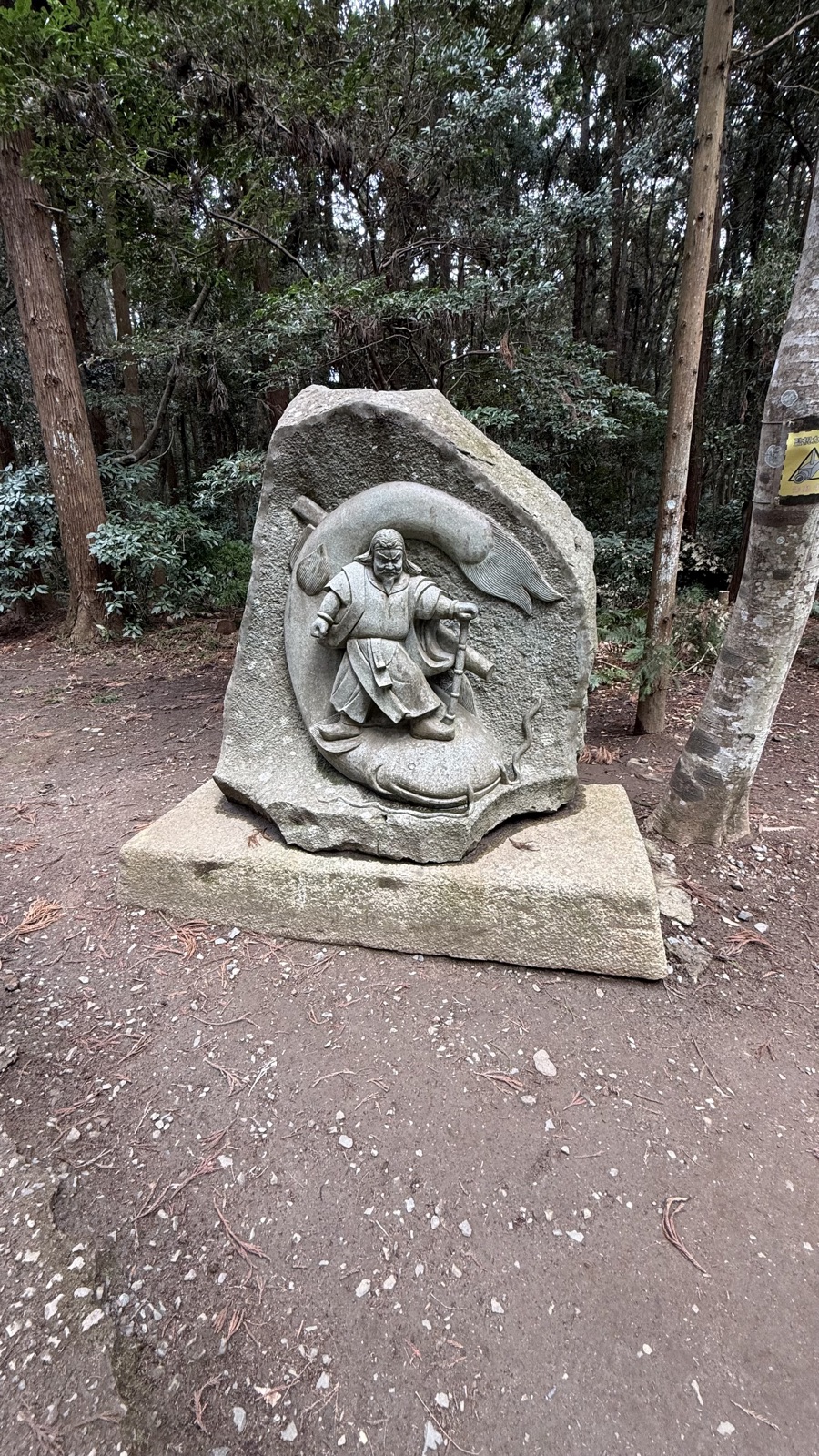 Stone carving of a warrior pinning down a giant catfish
