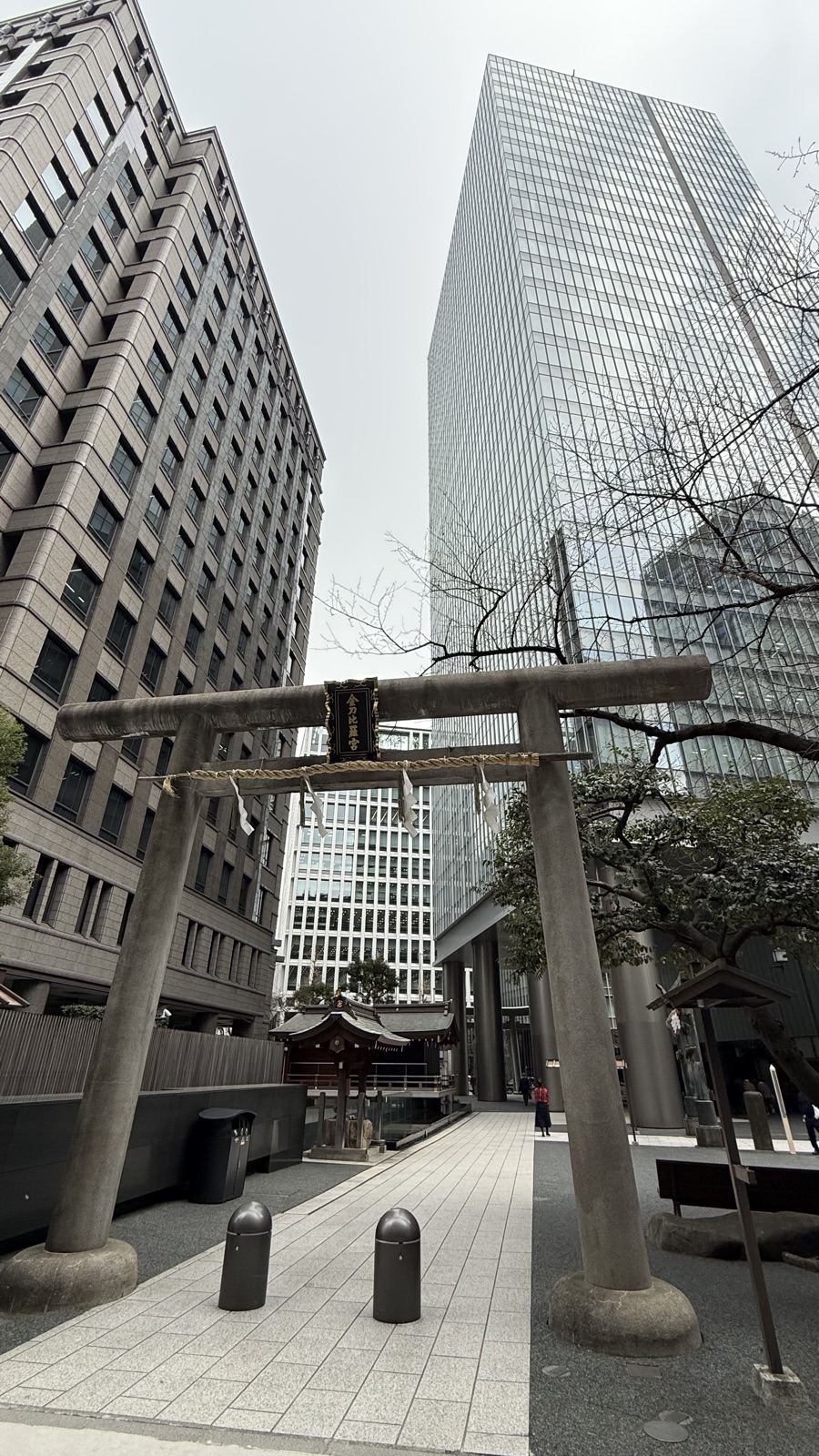 A stone torii rising between two buildings